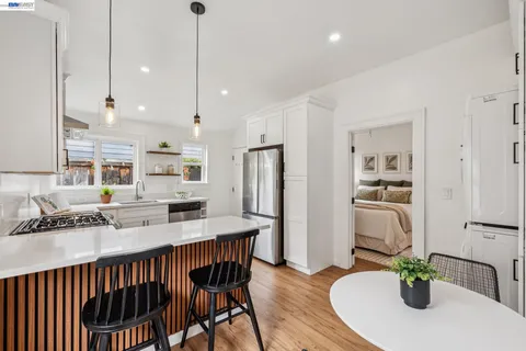 a kitchen with stainless steel appliances a refrigerator a sink a stove a microwave a center island and furniture