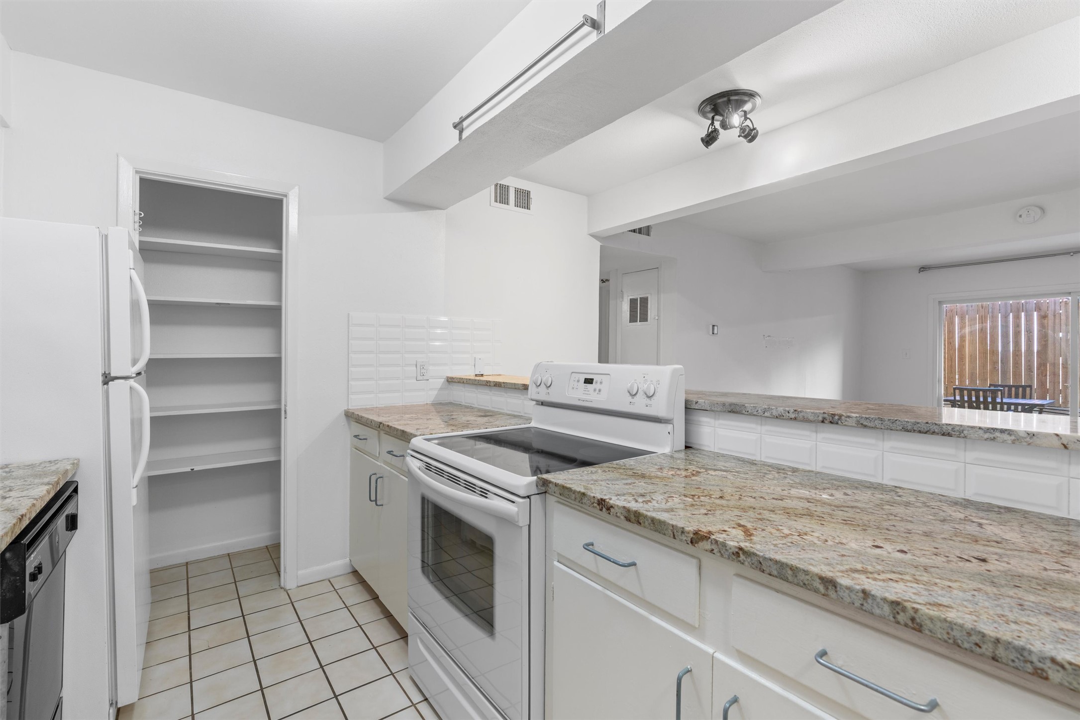 2208 Enfield Road, Unit 10500 Austin, TX 78703 - Photo 16 of 34 Kitchen featuring a white appliance suite, light-toned stone countertops, and white cabinetry