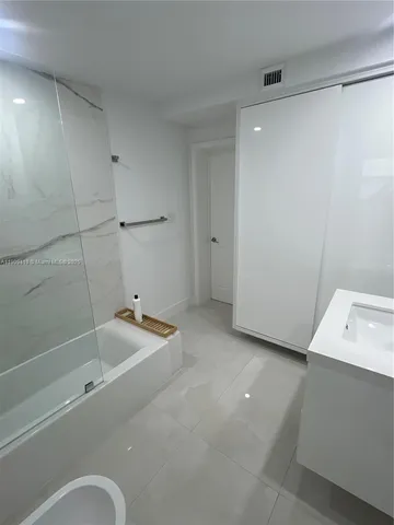 a bathroom with a tub a sink and a shower