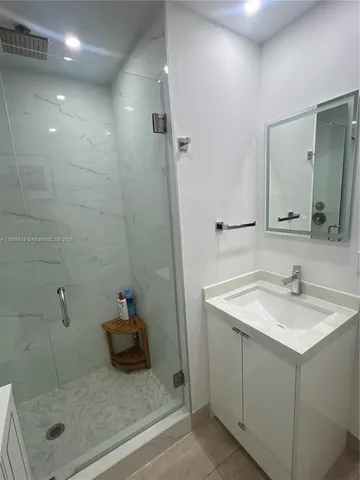 a bathroom with a shower sink and mirror