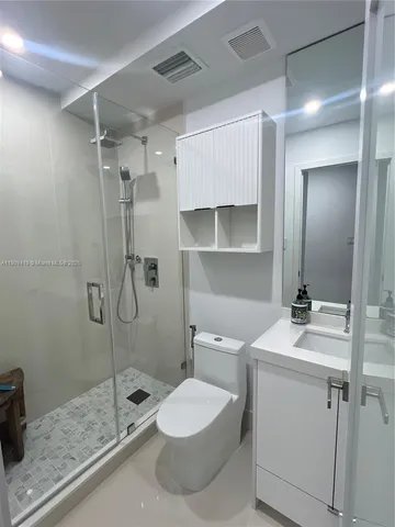 a bathroom with a granite countertop sink toilet and shower