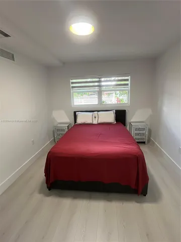 a spacious bedroom with a bed and window