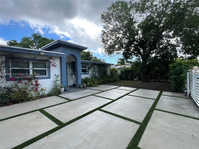 a view of a house with a yard and potted plants