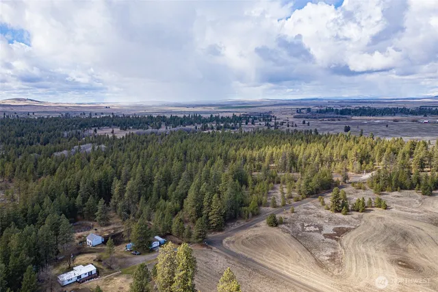 a view of a terrace with a table and chairs under an umbrella