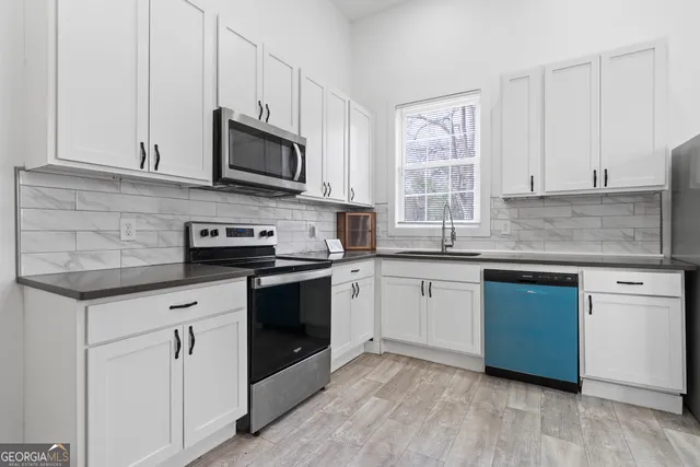 a kitchen with a refrigerator sink and stove top oven