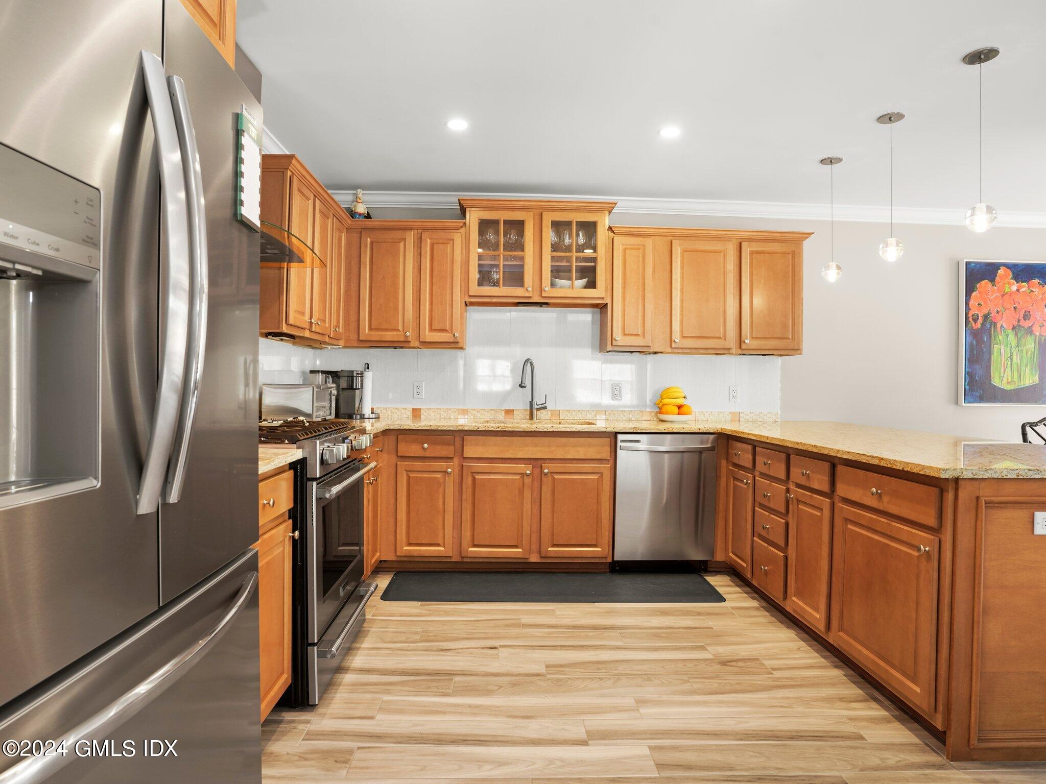 32 Cliff Avenue, Unit 3 Greenwich, CT 06830 - Photo 6 of 23 a kitchen with stainless steel appliances granite countertop a refrigerator sink and wooden cabinets