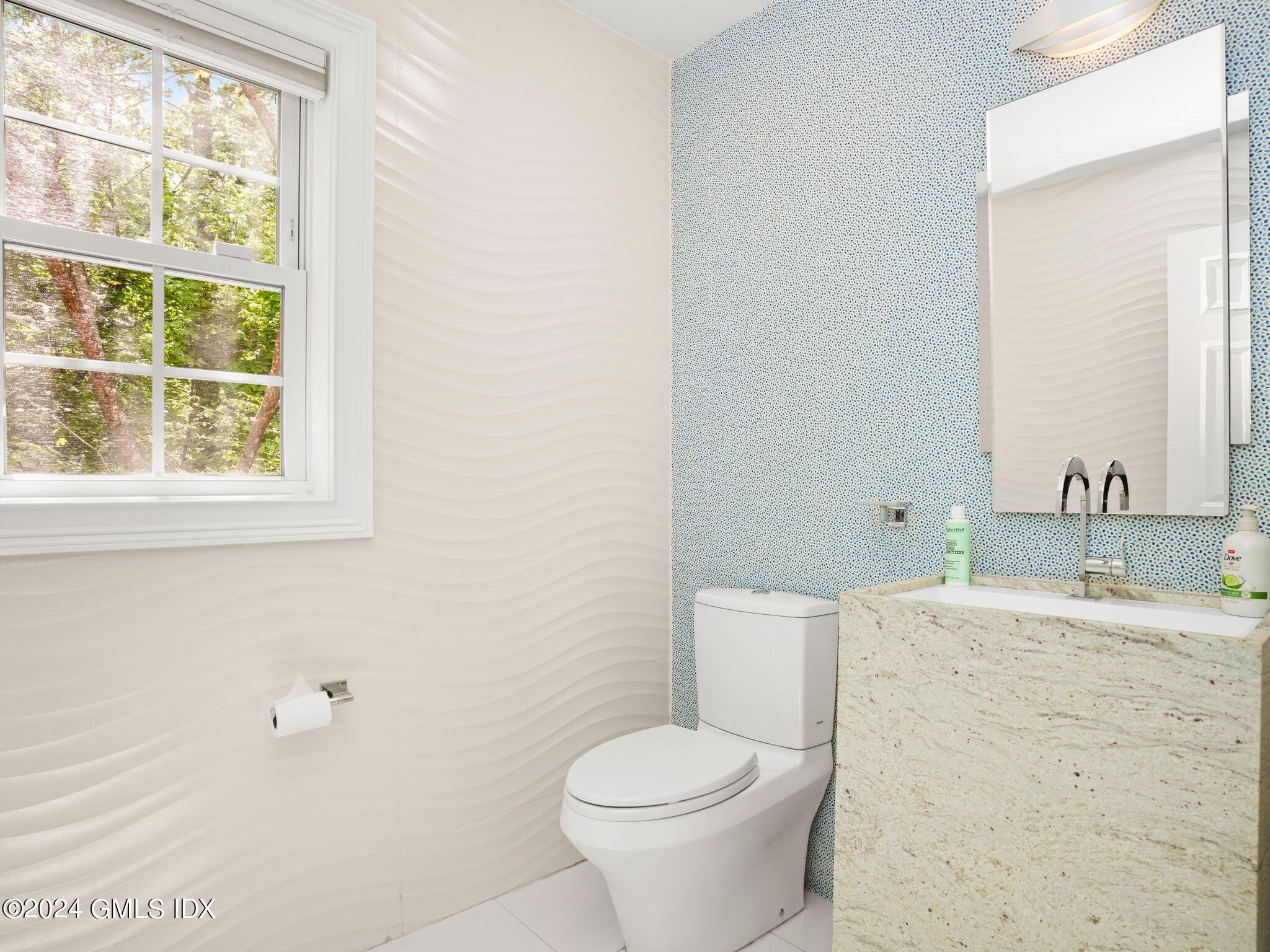 32 Cliff Avenue, Unit 3 Greenwich, CT 06830 - Photo 9 of 23 a bathroom with a granite countertop toilet a sink and a mirror