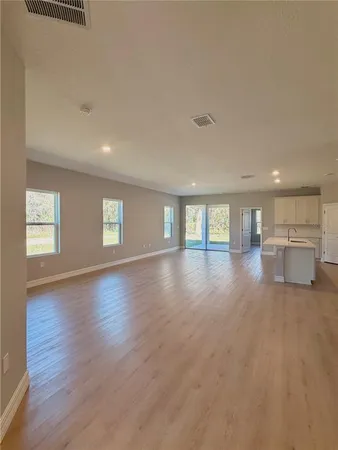 a view of empty room with wooden floor and window