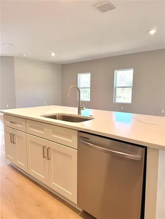a view with granite countertop white cabinets and a sink