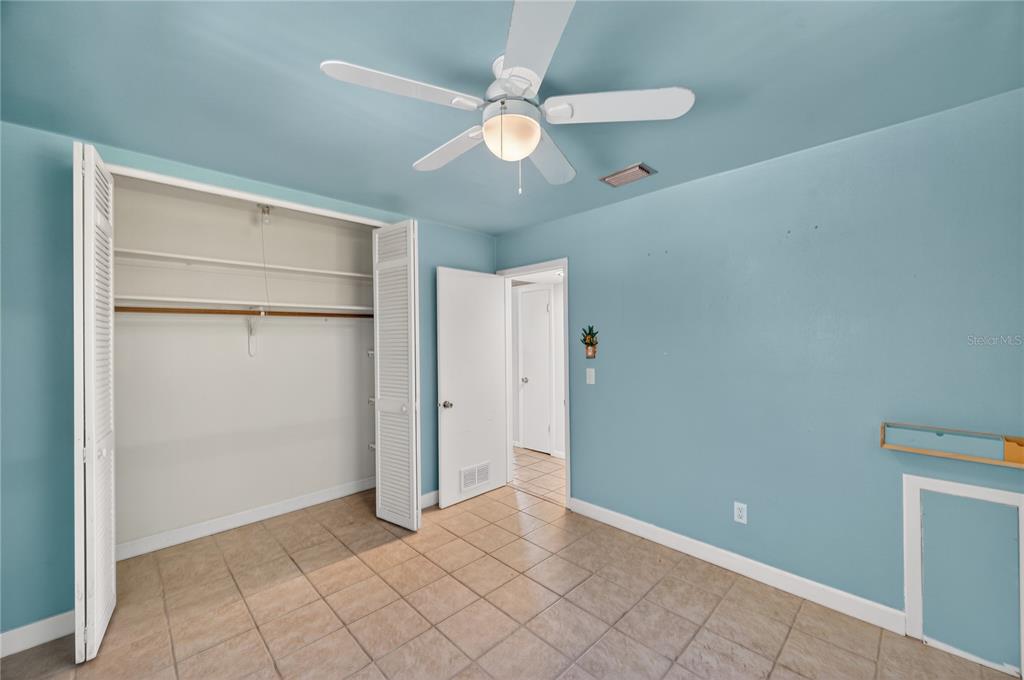 1417 Spring Lane Clearwater, FL 33755 - Photo 15 of 28 an empty room with closet and a chandelier fan