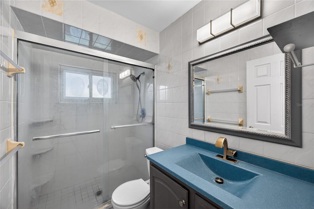 1417 Spring Lane Clearwater, FL 33755 - Photo 18 of 29 a bathroom with a sink toilet a mirror and shower