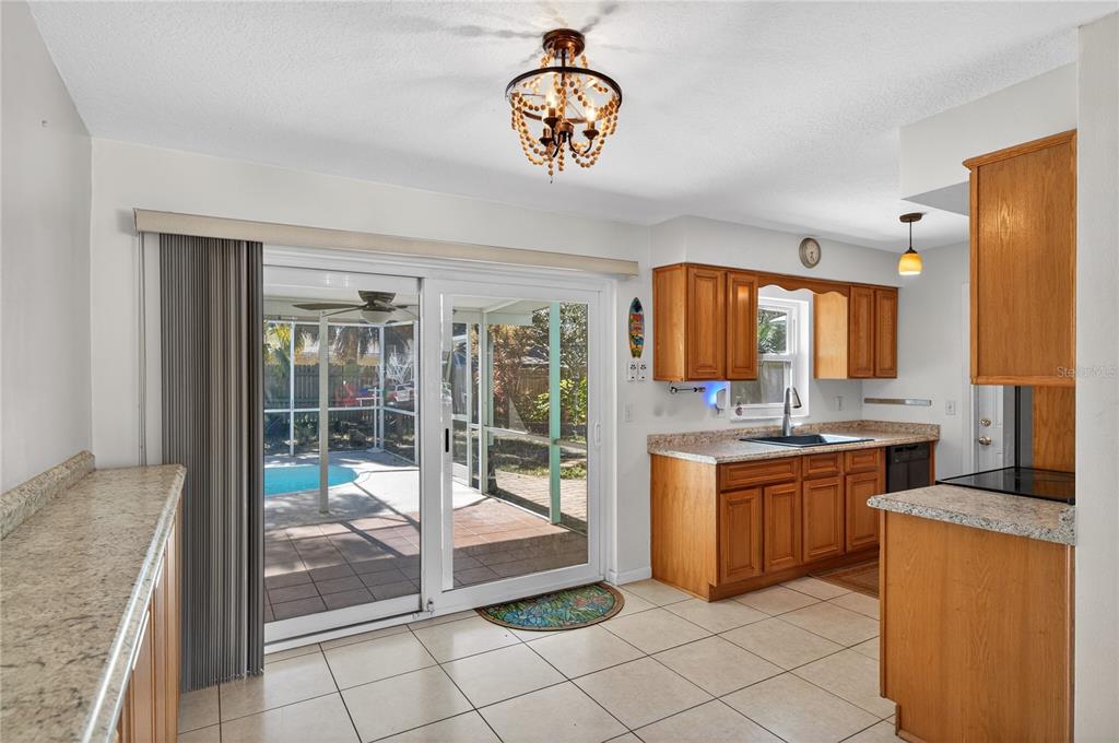 1417 Spring Lane Clearwater, FL 33755 - Photo 7 of 28 a open kitchen with granite countertop a stove top oven a sink and a granite counter top