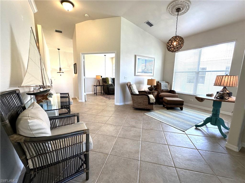 1965 Crestview Way, Unit 156 Naples, FL 34119 - Photo 16 of 45 a living room with furniture a large window and a chandelier