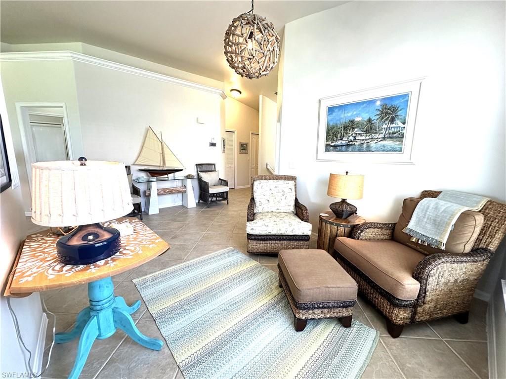 1965 Crestview Way, Unit 156 Naples, FL 34119 - Photo 17 of 45 a living room with furniture and a chandelier
