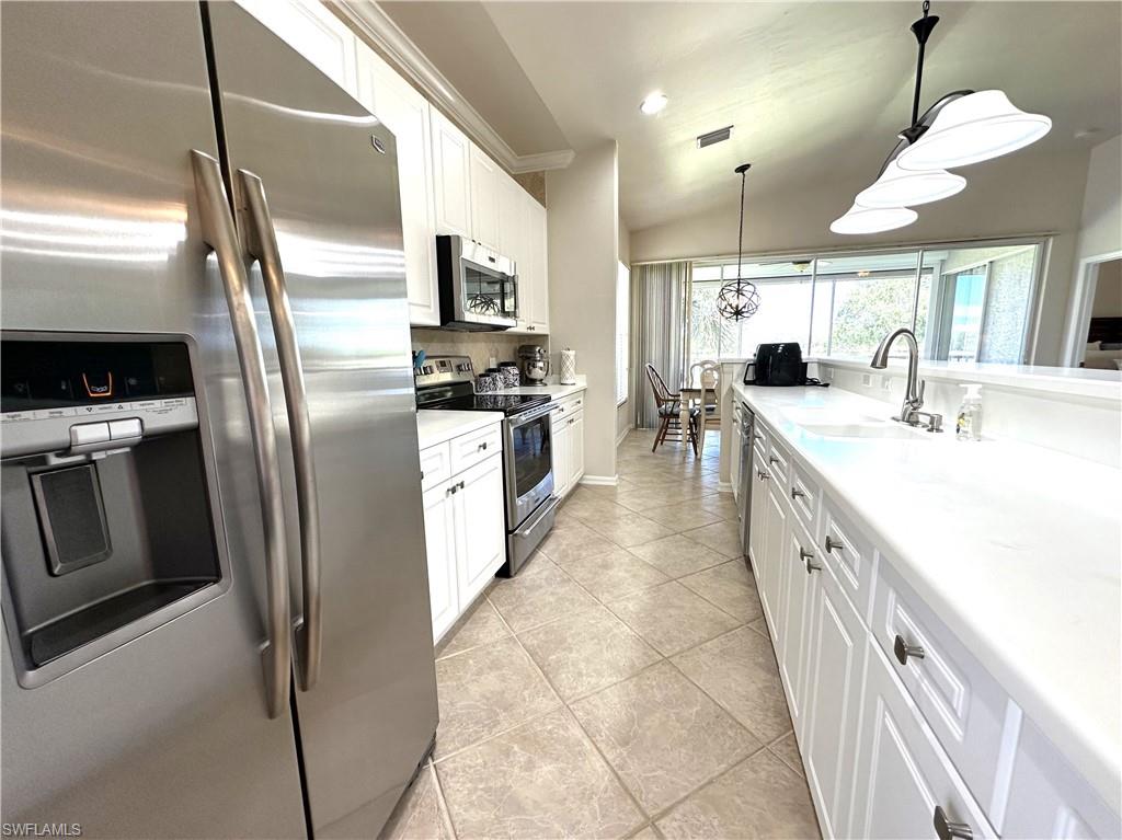 1965 Crestview Way, Unit 156 Naples, FL 34119 - Photo 24 of 45 a large kitchen with a large counter top appliances and cabinets