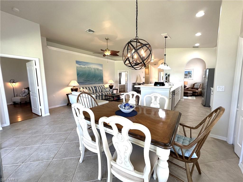1965 Crestview Way, Unit 156 Naples, FL 34119 - Photo 26 of 45 a view of a dining room and livingroom with furniture wooden floor a rug a fireplace and a chandelier