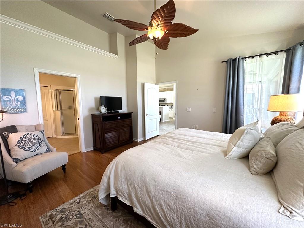 1965 Crestview Way, Unit 156 Naples, FL 34119 - Photo 28 of 45 a bedroom with a bed a couch and a chandelier