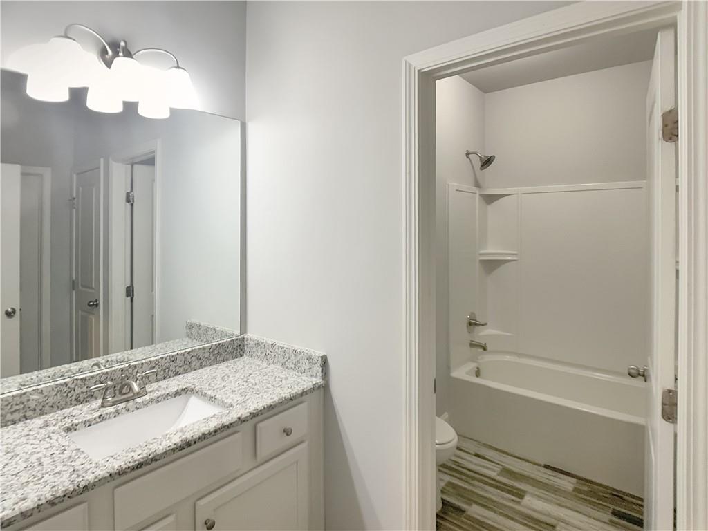 908 West Union Grove Circle Auburn, GA 30011 - Photo 13 of 16 a bathroom with a granite countertop sink a mirror and a bathtub