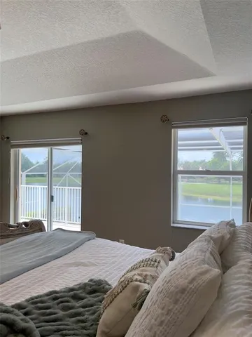 a bedroom with a bed and a large window