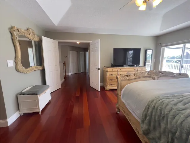 a spacious bedroom with a bed and a flat screen tv