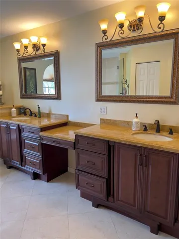 a bathroom with a granite countertop double vanity sink and a mirror