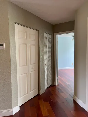 an empty room with wooden floor and closet area