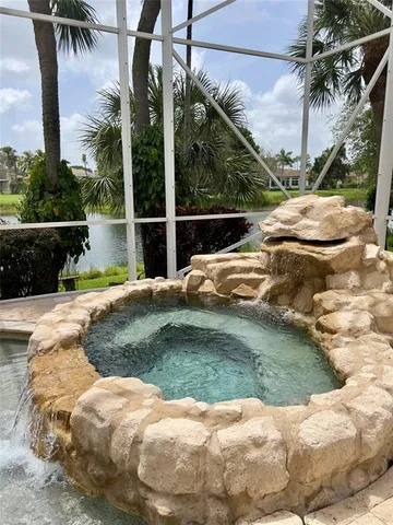 a view of swimming pool with a garden and patio