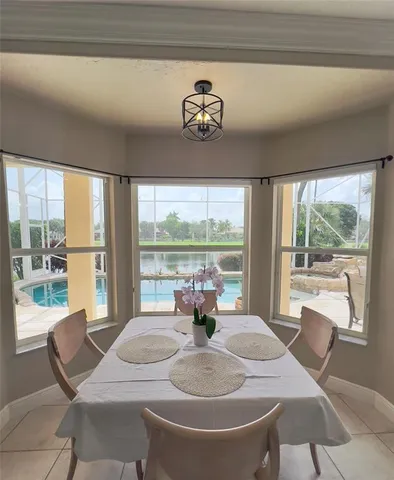 a dining room with furniture large windows and wooden floor