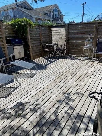 a view of a chairs and table on the wooden roof deck