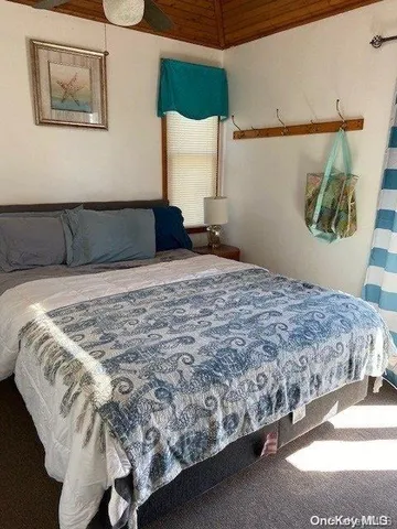 a bedroom with a bed and painting on the wall