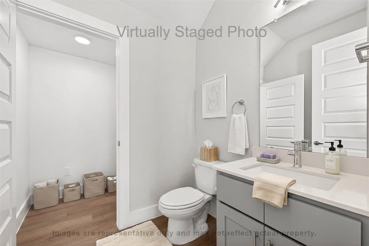 10719 Mason Road, Unit 15 Richmond, TX 77406 - Photo 23 of 50 Virtual Staging - Modern bathroom featuring a gray vanity, a large mirror, and an open doorway leading to a storage area with woven baskets