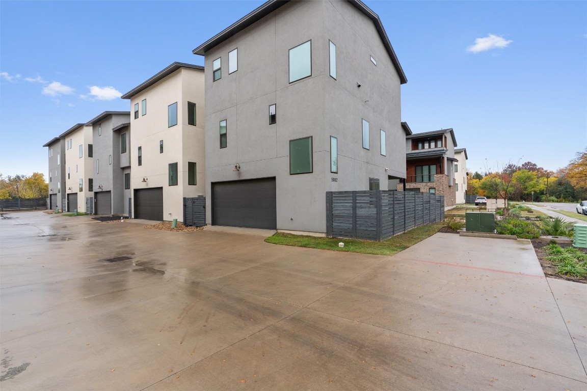 View of side of property featuring stucco siding, driveway, and a garage