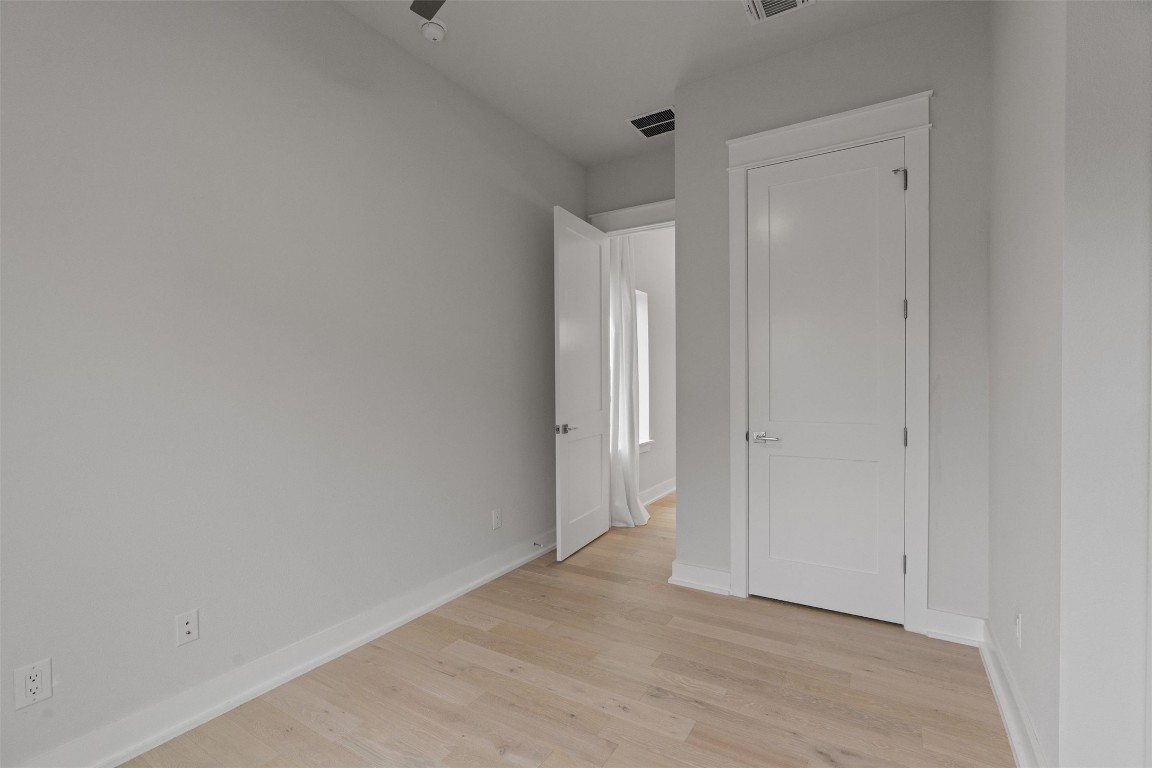 5002 Pecan Springs Road, Unit 1 Austin, TX 78723 - Photo 21 of 38 Unfurnished bedroom featuring light wood-style flooring and baseboards