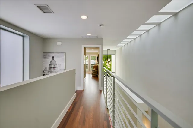 a view of a hallway with wooden floor and staircase