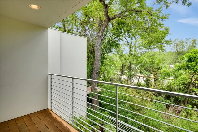 a view of a balcony with wooden floor and fence