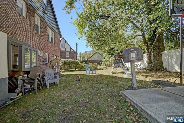 a view of a house with backyard and sitting area