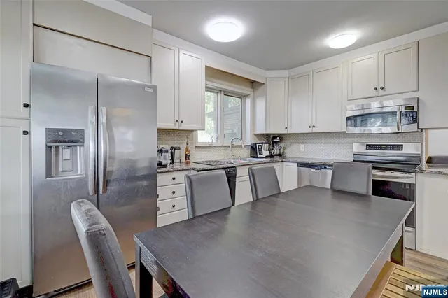 a large kitchen with cabinets stainless steel appliances and a center island