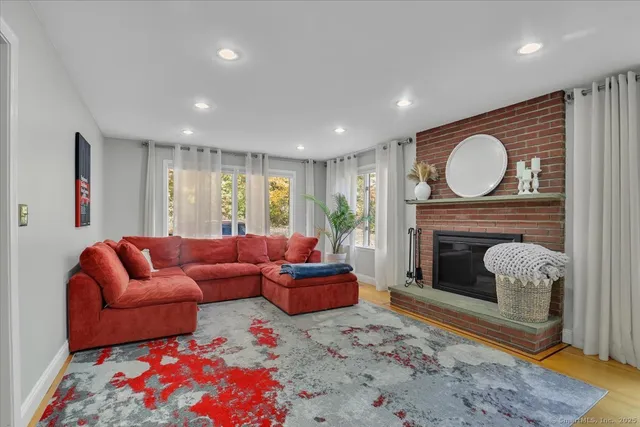 a living room with furniture a fireplace and a floor to ceiling window