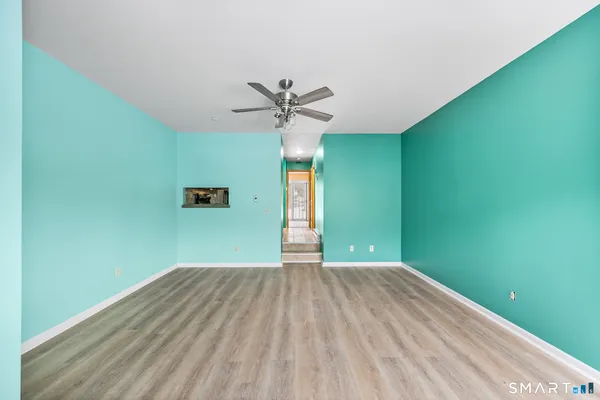 a view of a big room with wooden floor and a ceiling fan