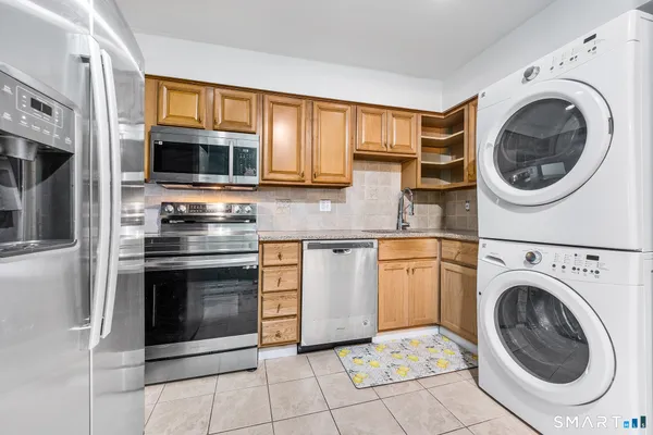 a kitchen with stainless steel appliances granite countertop a stove a microwave and a sink
