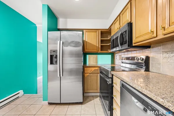 a kitchen with stainless steel appliances granite countertop a refrigerator and a stove