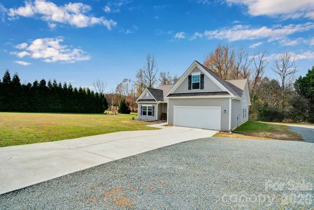 a house with green field in front of it