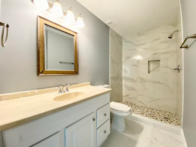 a bathroom with a sink a toilet and shower