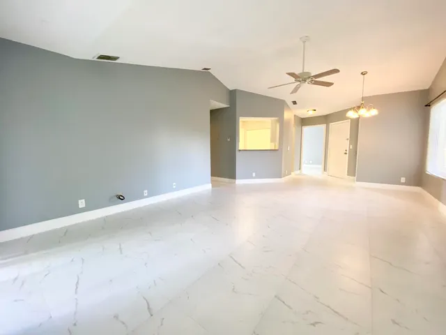 a view of a livingroom with a chandelier fan and a window