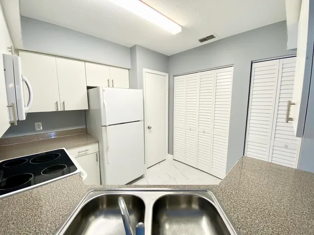 a kitchen with a refrigerator and a sink