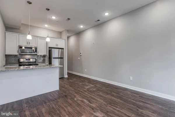 a view of an empty room with wooden floor