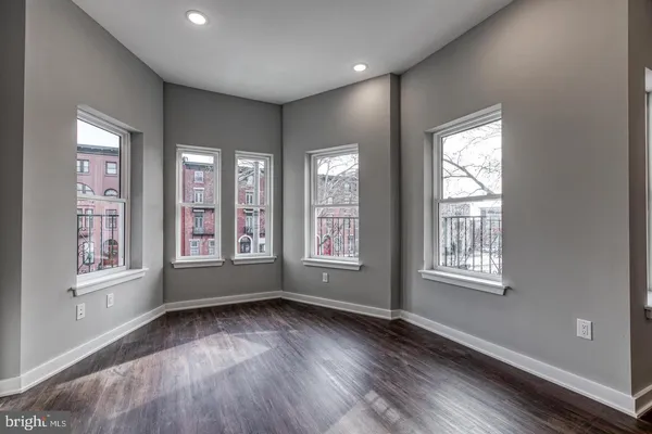 a view of an empty room with wooden floor