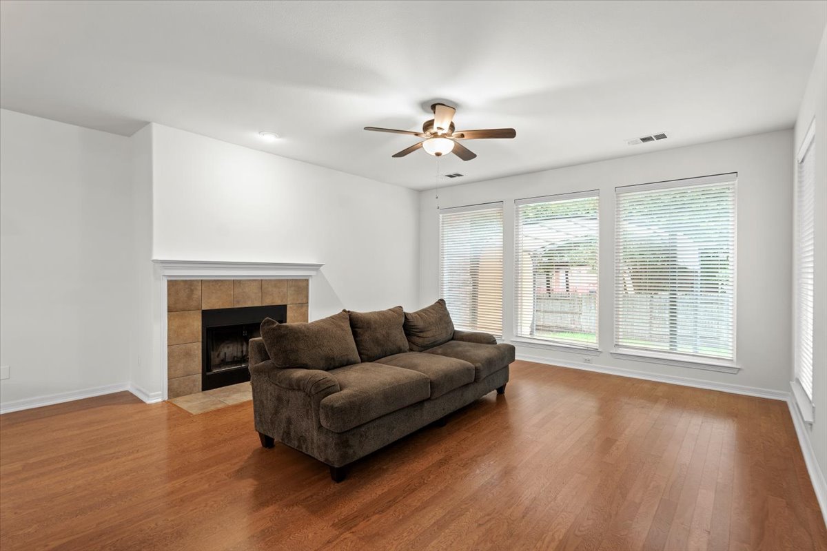 2304 Village View Loop Pflugerville, TX 78660 - Photo 14 of 40 A comforting living space features rich hardwood flooring and a warming fireplace with tile surround.