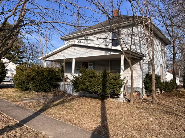 a view of a house with yard and sitting area