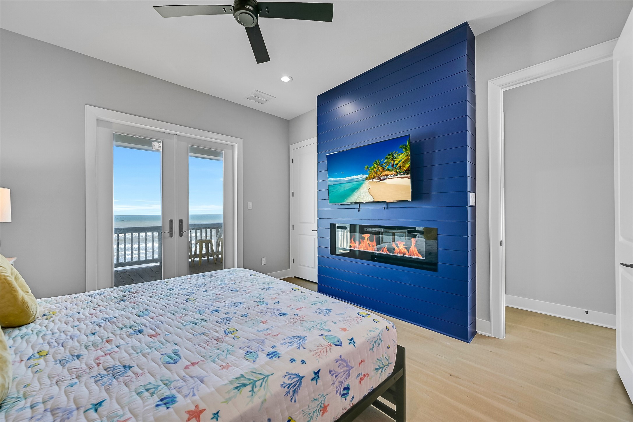 16728 West Beach Road Jamaica Beach, TX 77554 - Photo 33 of 46 The bedroom includes a spacious closet, south-facing deck access, and an electric fireplace framed with shiplap for added charm.